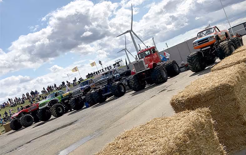 Monster trucks lined up along the track