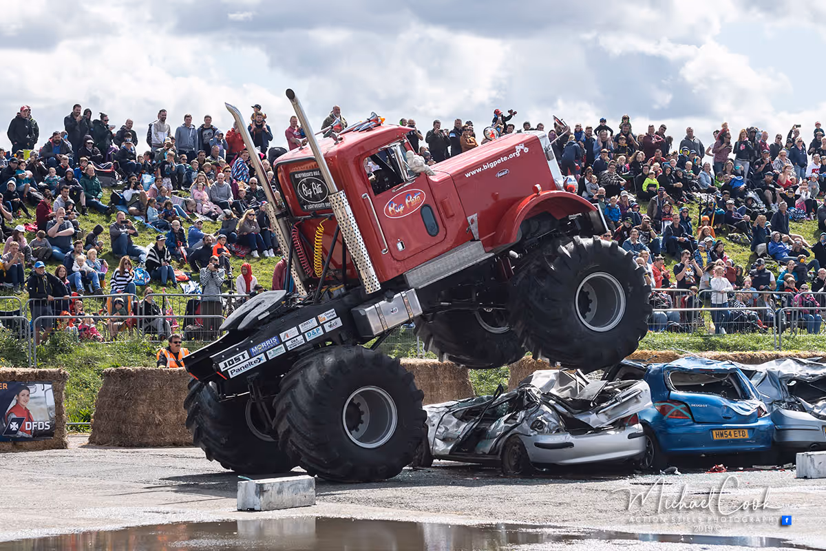 Big Pete, a red monster lorry cab, driving over crushed cars