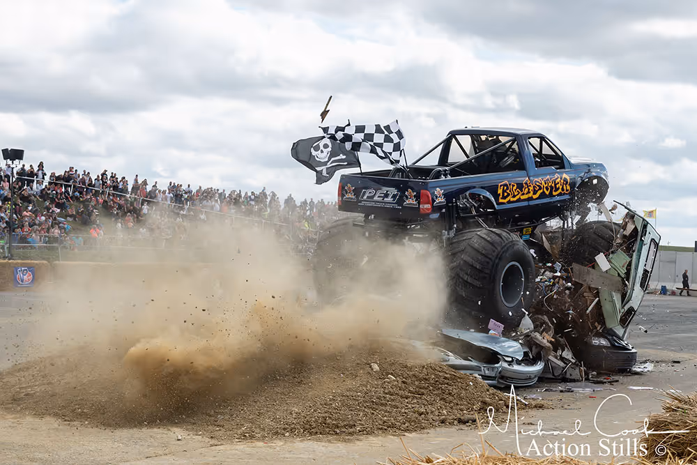 Blaster ploughing through cars in a cloud of dirt