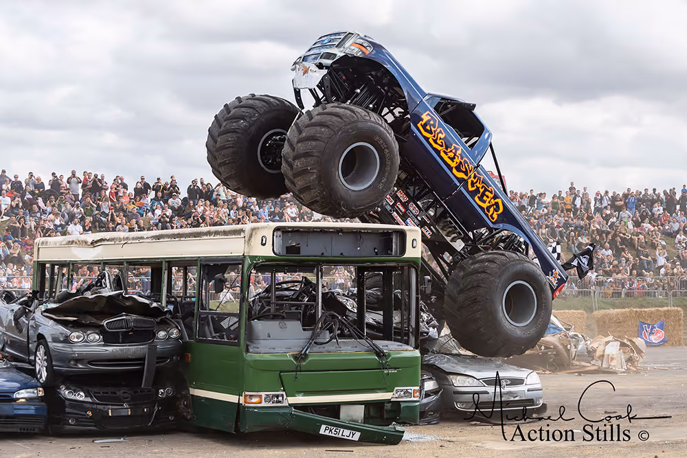 Blaster on top of a green bus and a row of cars