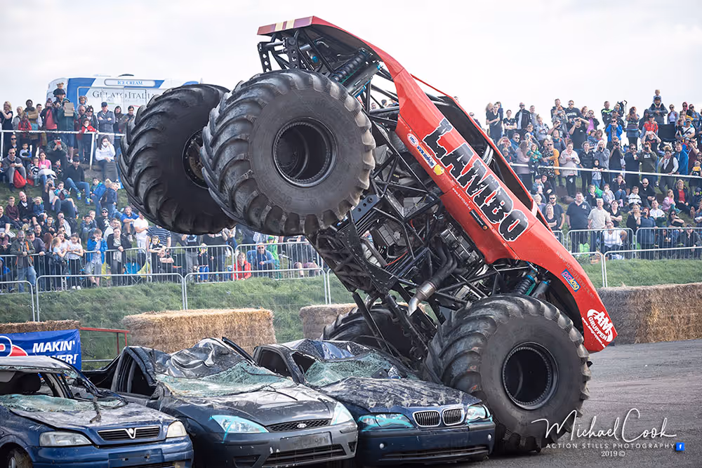 Lambo standing up on its rear wheels on top of crushed cars