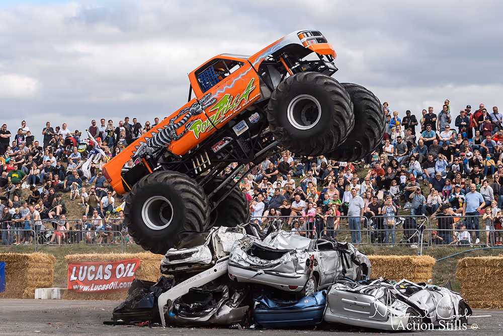 Podzilla climbing over a pile of crushed cars