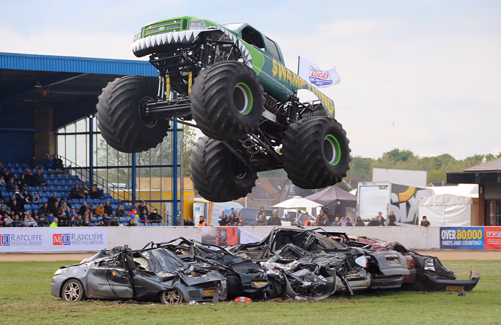 Swamp Thing jumping over a row of crushed cars