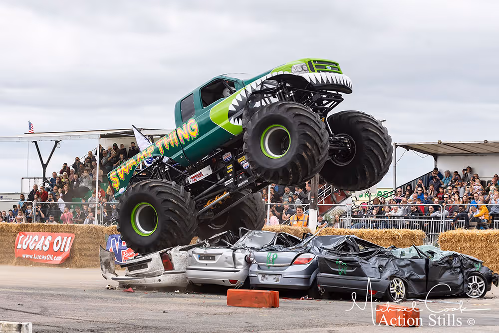 Swamp Thing climbing over crushed cars